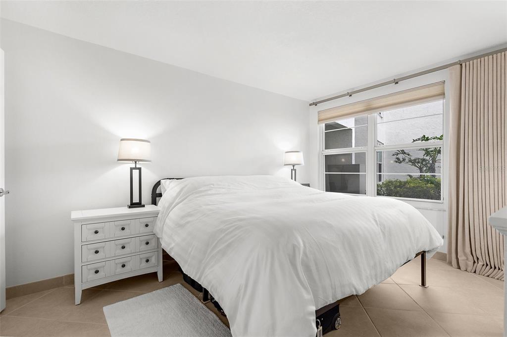 600 Sutton Place, Unit 101B Longboat Key, FL 34228 - Photo 15 of 53 a large bed sitting in a bedroom next to a window