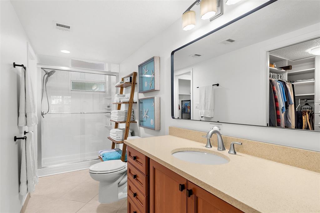 600 Sutton Place, Unit 101B Longboat Key, FL 34228 - Photo 18 of 53 a bathroom with a sink a toilet and shower