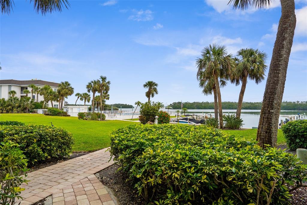 600 Sutton Place, Unit 101B Longboat Key, FL 34228 - Photo 21 of 53 a view of a garden with a building in the background