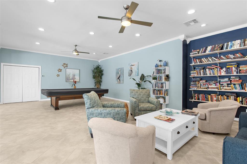 600 Sutton Place, Unit 101B Longboat Key, FL 34228 - Photo 38 of 53 a living room with furniture and a book shelf