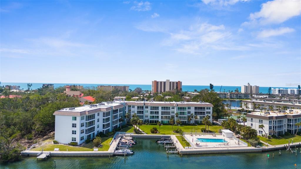600 Sutton Place, Unit 101B Longboat Key, FL 34228 - Photo 4 of 53 a view of a swimming pool with outdoor seating and a residential buildings