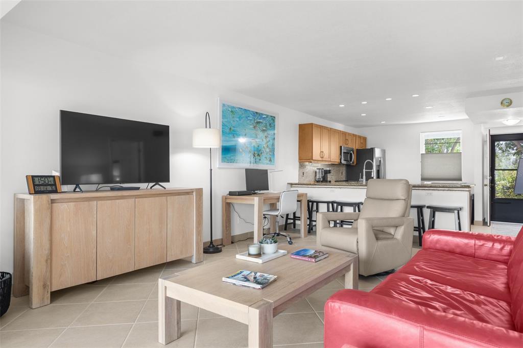 600 Sutton Place, Unit 101B Longboat Key, FL 34228 - Photo 8 of 53 a living room with furniture and a flat screen tv