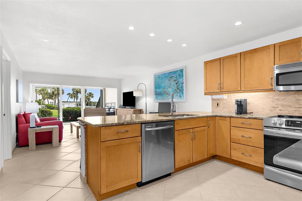 600 Sutton Place, Unit 101B Longboat Key, FL 34228 - Photo 9 of 53 a kitchen with a sink stove and cabinets