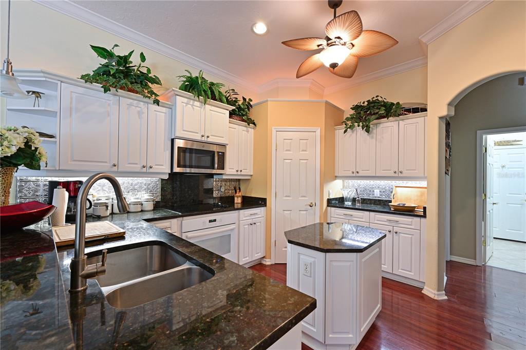 6602 Tallmast Circle Lakewood Ranch, FL 34202 - Photo 12 of 43 a kitchen with stainless steel appliances granite countertop a stove refrigerator sink and microwave