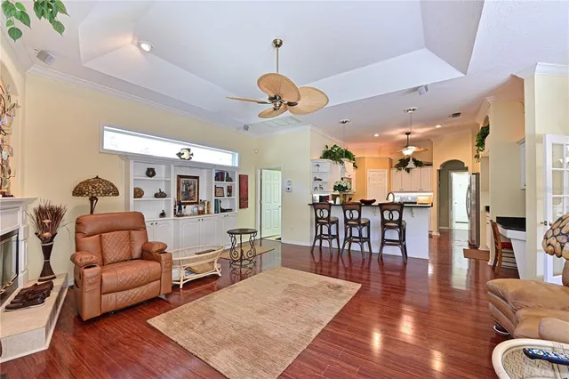 a living room with furniture kitchen view and a wooden floor
