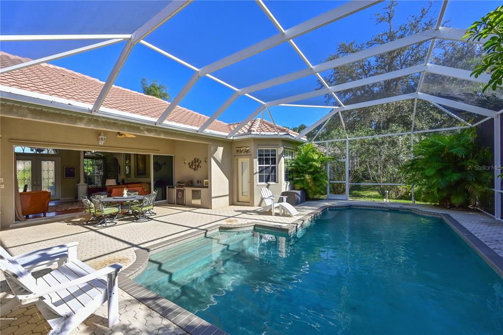 6602 Tallmast Circle Lakewood Ranch, FL 34202 - Photo 5 of 43 a view of a patio with table and chairs under an umbrella