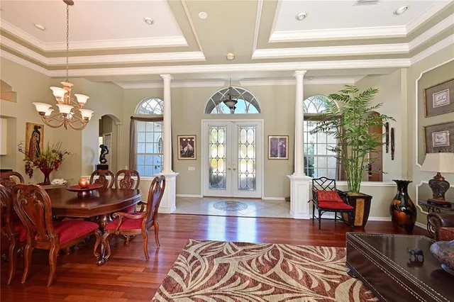 a view of a dining room with furniture a chandelier and wooden floor