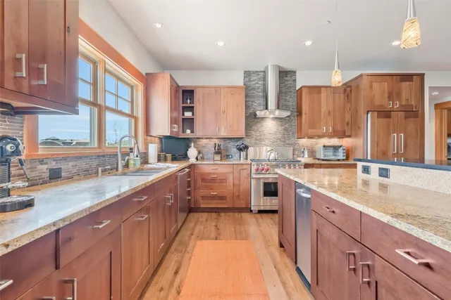 a large kitchen with a large window and stainless steel appliances