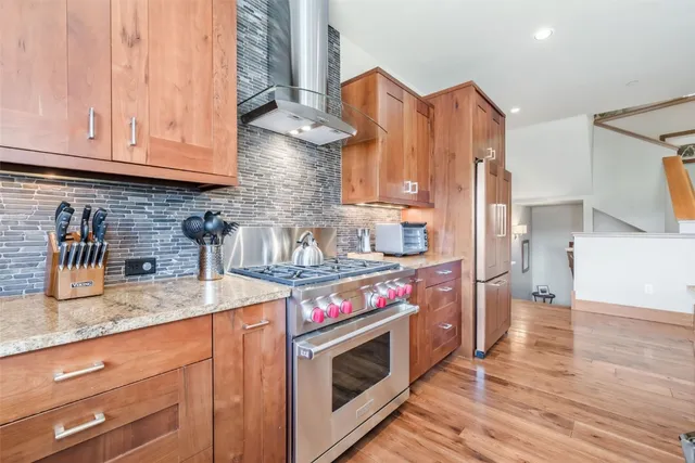 a kitchen with stainless steel appliances granite countertop a stove a sink and a microwave