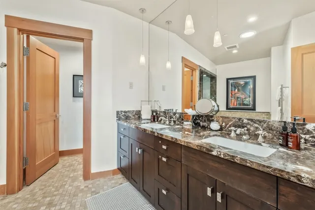 a bathroom with double vanity sinks a vanity a mirror and a shower