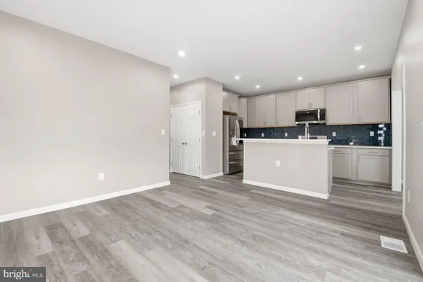 a kitchen with kitchen island white cabinets appliances and sink