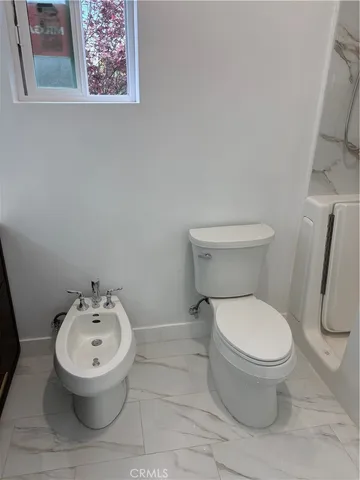 a white toilet sitting next to a bathroom sink