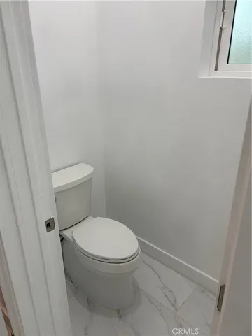 a white toilet sitting next to a shower