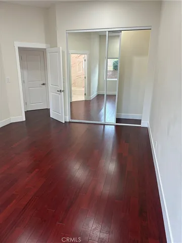 an empty room with wooden floor and closet