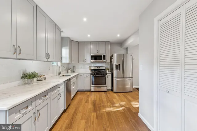 a kitchen with granite countertop a refrigerator and a stove top oven