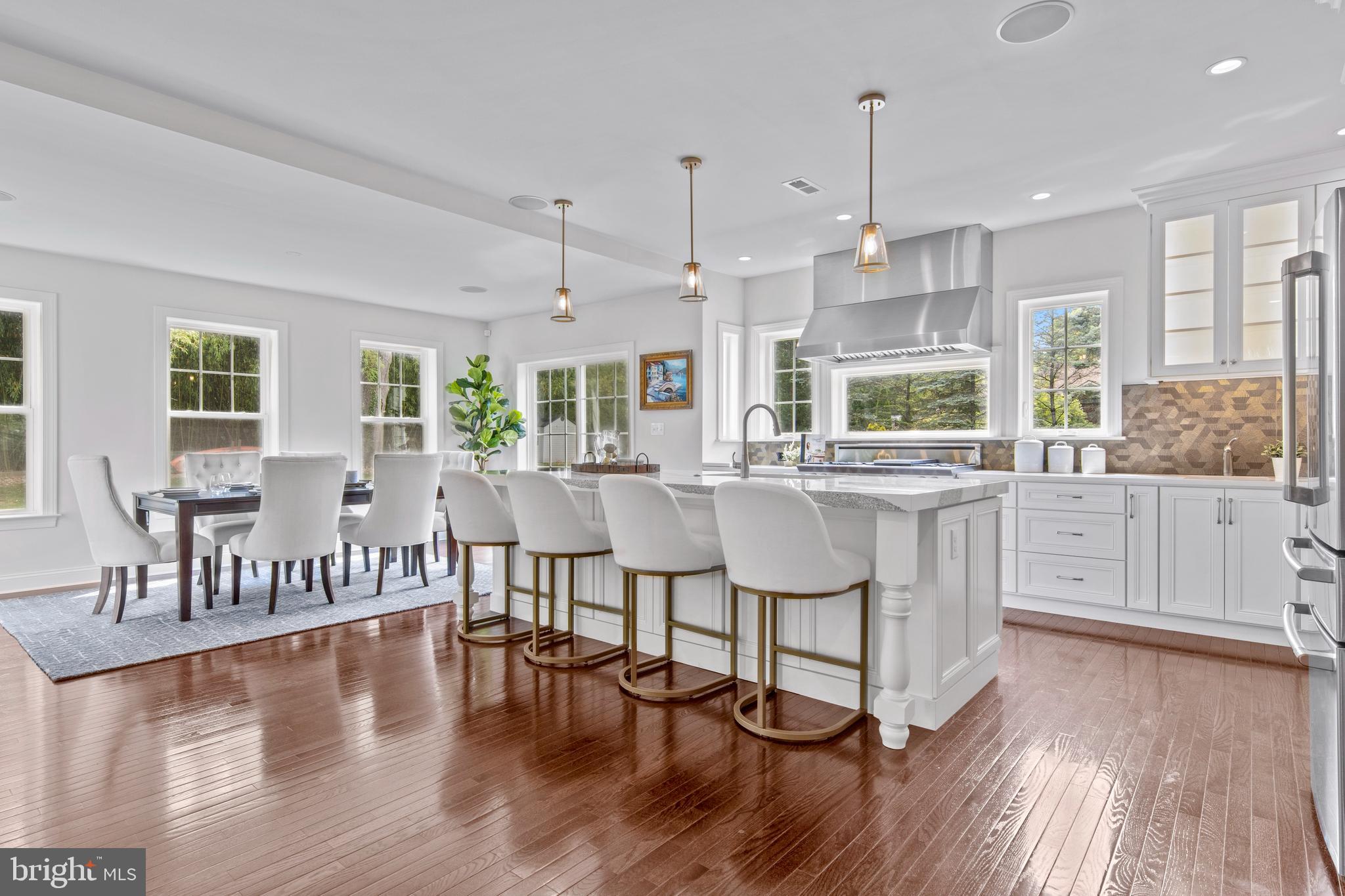 444 Conestoga Road Wayne, PA 19087 - Photo 19 of 82 a kitchen with stainless steel appliances granite countertop a stove top oven a sink dishwasher and white cabinets with wooden floor