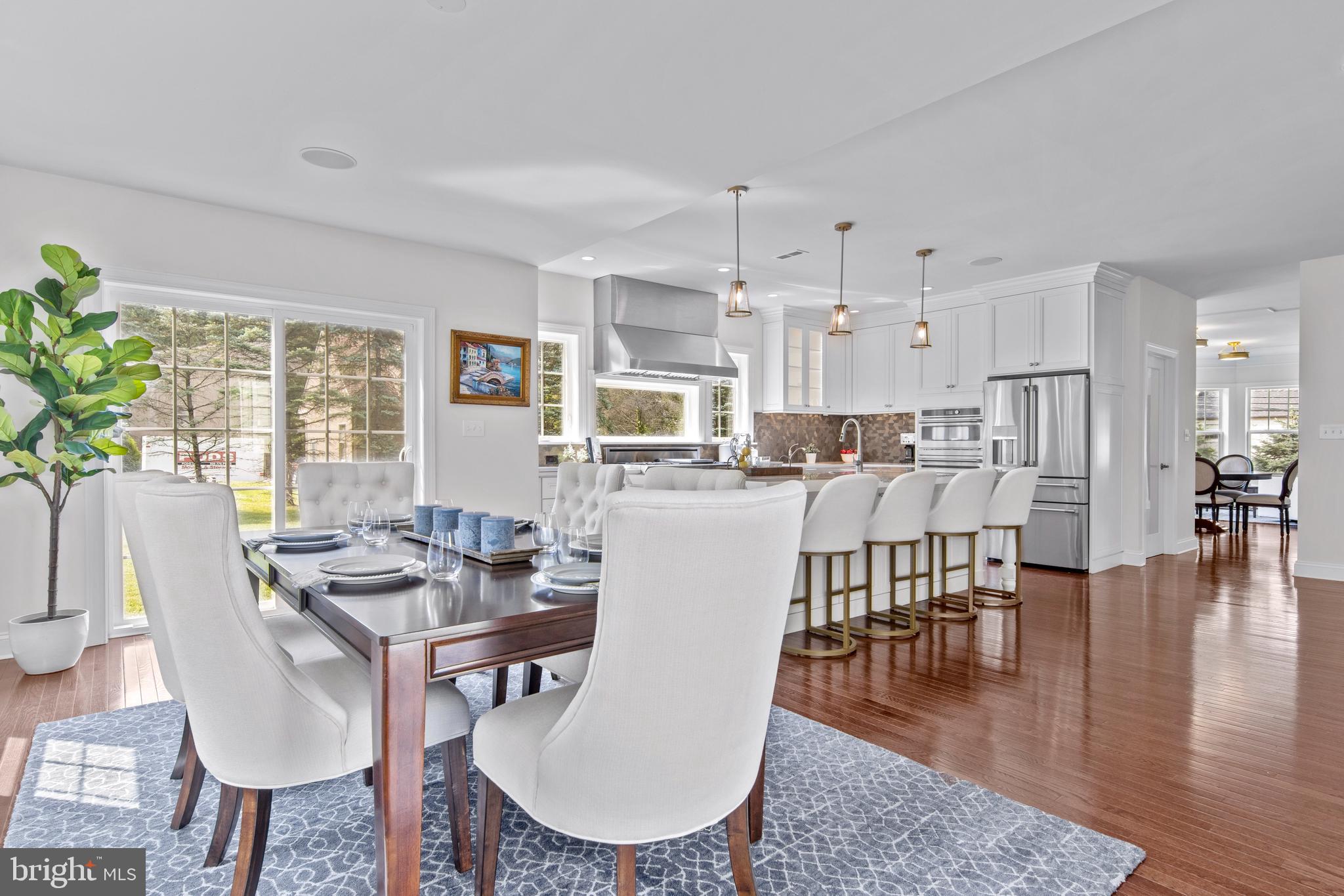 444 Conestoga Road Wayne, PA 19087 - Photo 30 of 82 a dining room with wooden floor a chandelier a glass table and chairs