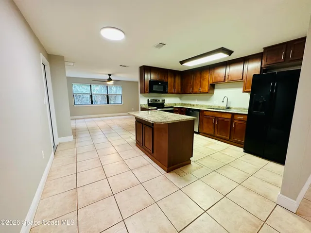 a kitchen with stainless steel appliances granite countertop a refrigerator and a stove top oven