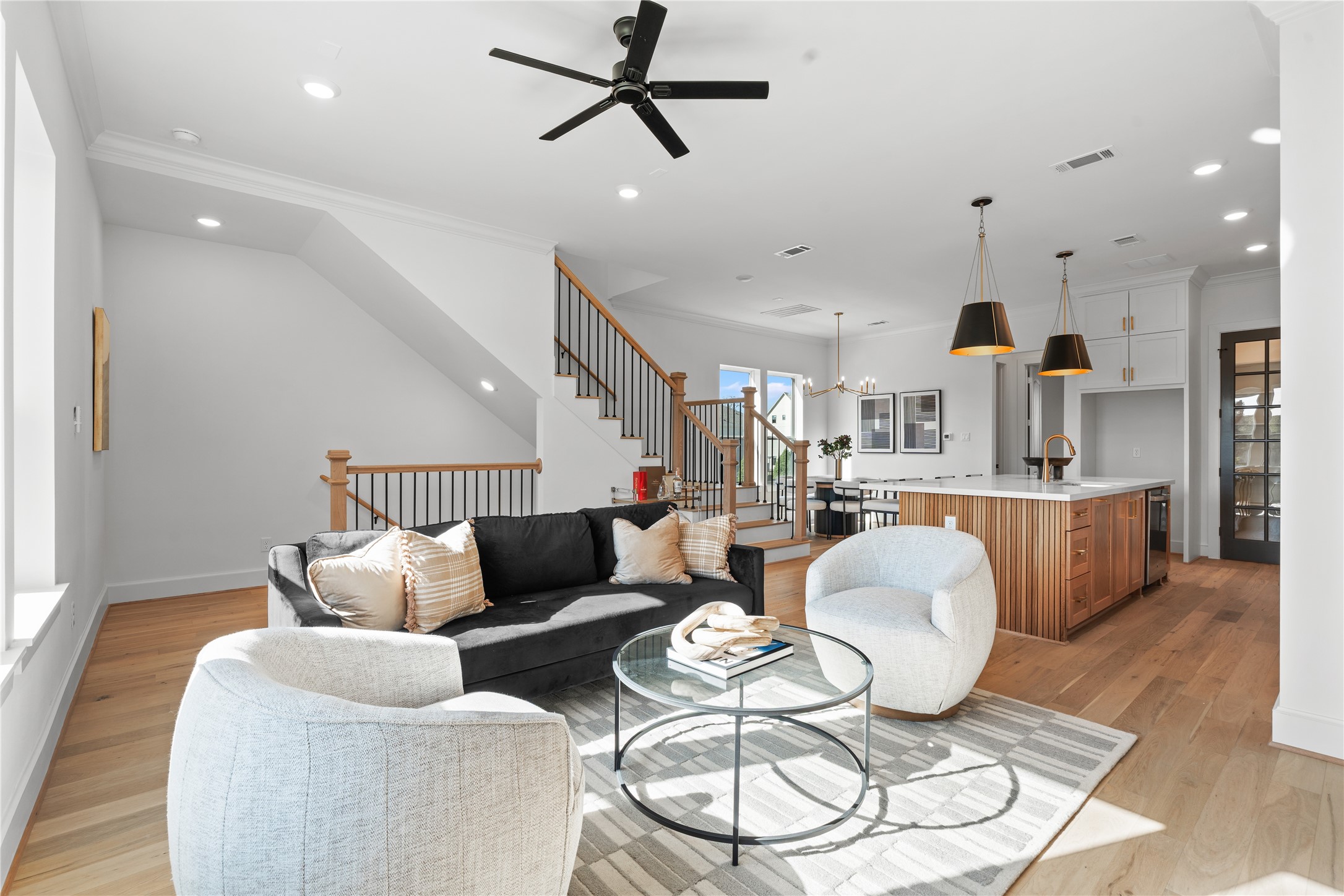 1614 Ojeman Road, Unit J Houston, TX 77055 - Photo 13 of 50 Spacious, open-concept living area is well-lit with natural light and has a cozy seating area with stylish decor and a contemporary staircase leading to the upper floor.