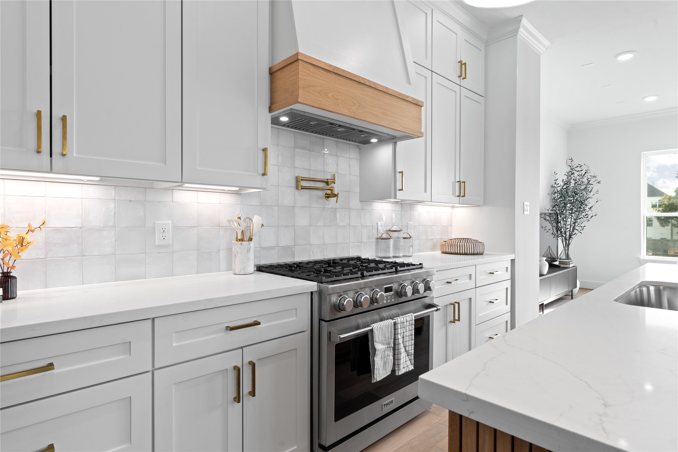 1614 Ojeman Road, Unit J Houston, TX 77055 - Photo 19 of 50 This gourmet kitchen is equipped with a premium Thor 6-burner gas range, complemented by a sleek pot filler and custom wood-accented vent hood - blending luxury, functionality, and timeless design.