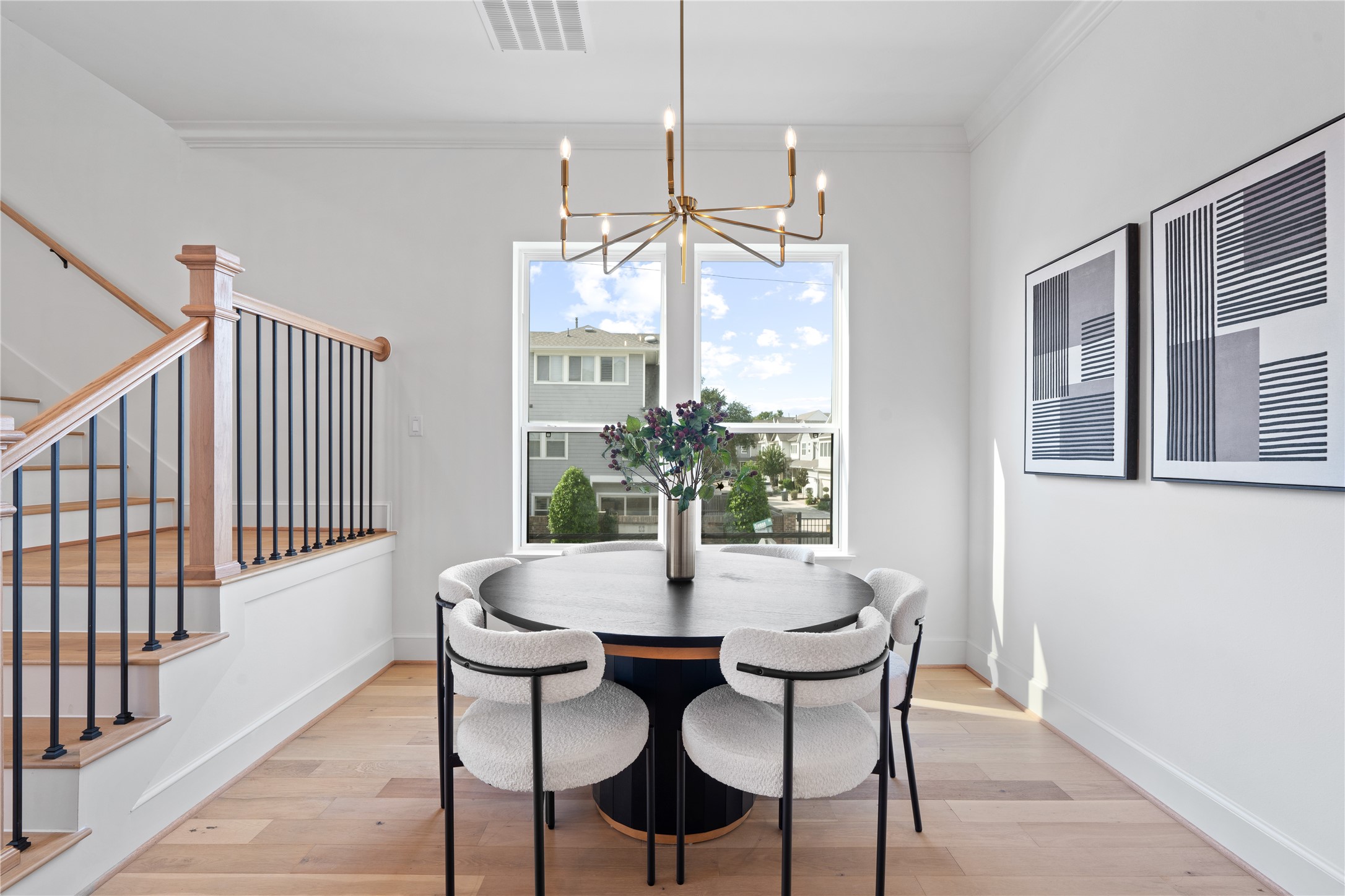 1614 Ojeman Road, Unit J Houston, TX 77055 - Photo 23 of 50 Elegant dining space featuring a modern chandelier, warm wood flooring, and an open layout that seamlessly connects to the kitchen and living areas - perfect for intimate gatherings or entertaining guests.