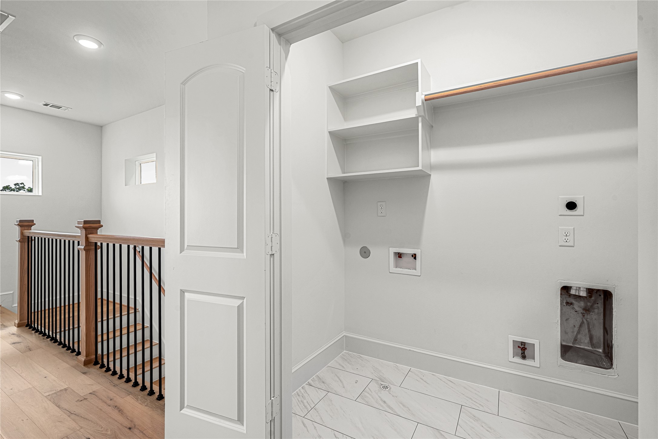 1614 Ojeman Road, Unit J Houston, TX 77055 - Photo 29 of 50 Utility room with hookups for a washer and dryer, tiled flooring, and built-in shelving for convenient storage and organization.