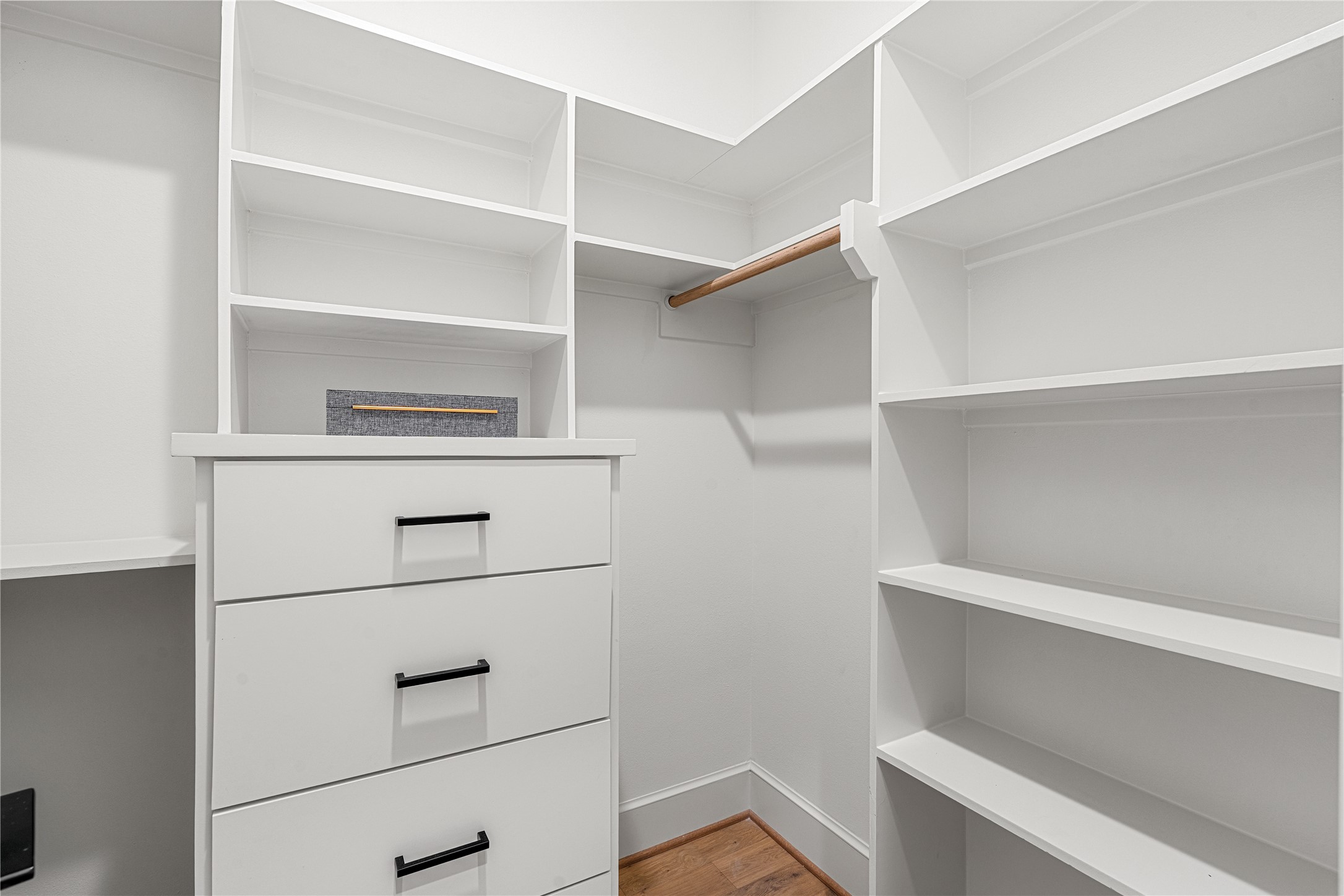 1614 Ojeman Road, Unit J Houston, TX 77055 - Photo 34 of 50 Spacious walk-in closet featuring white shelving and drawers, a spaces to hanging clothes, and ample storage on both sides. Perfect for organizing clothing and accessories.