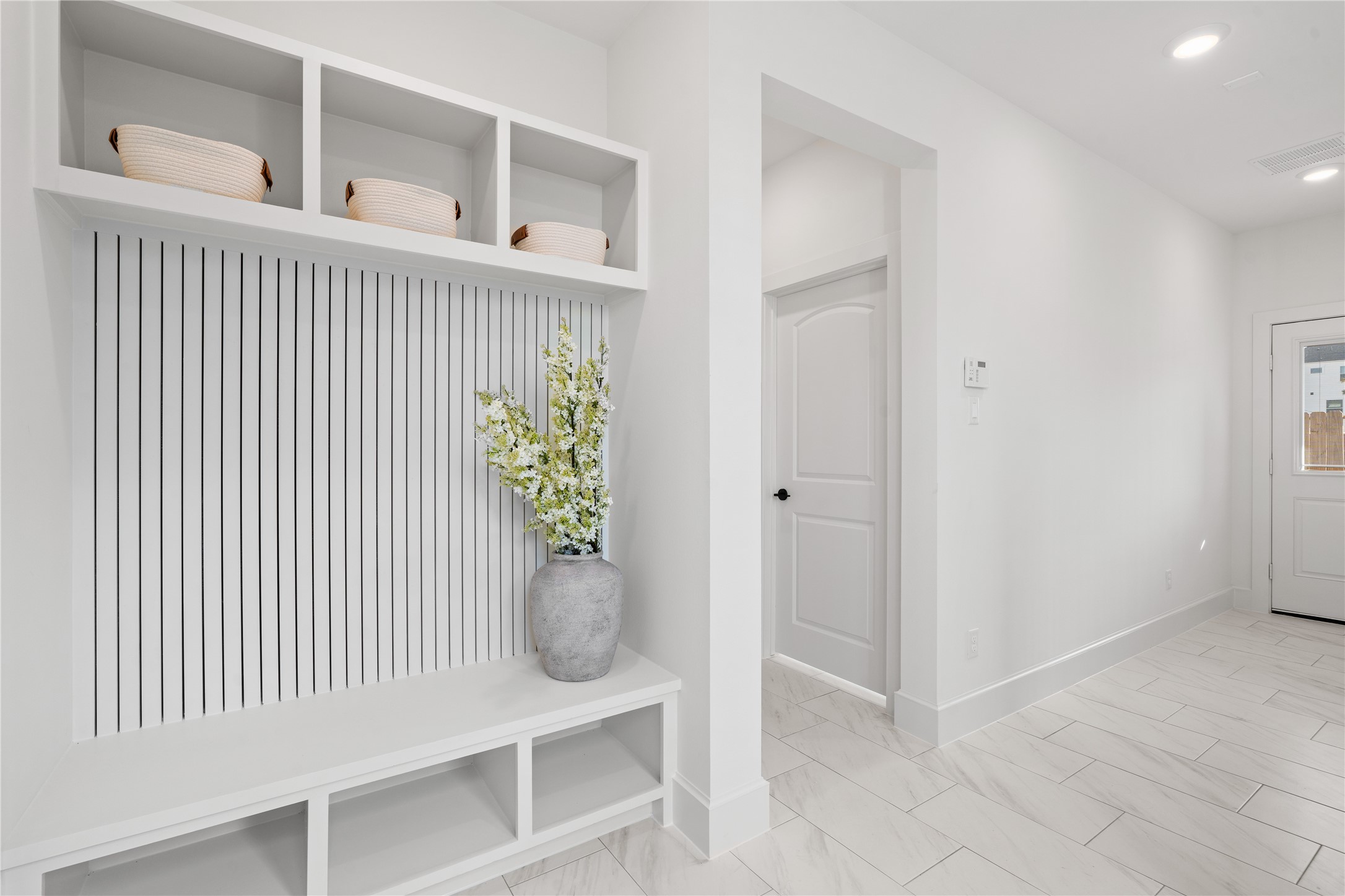 1614 Ojeman Road, Unit J Houston, TX 77055 - Photo 6 of 50 Welcoming foyer with built-in bench seating and storage cubbies. The space features sleek tile flooring, recessed lighting, and a view into an first floor room with stylish decor.