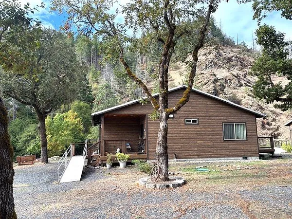 a view of a house with backyard and trees