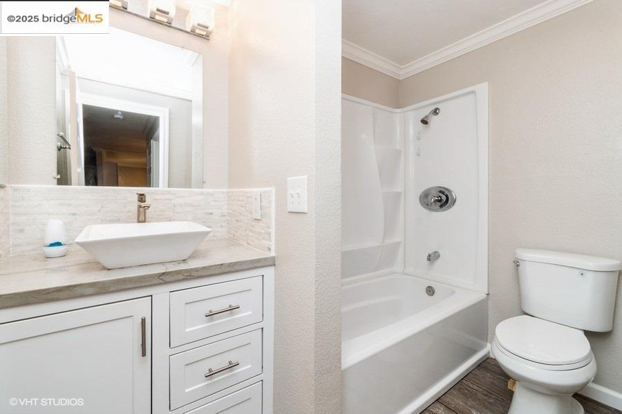 1505 Kirker Pass Road, Unit 170 Concord, CA 94521 - Photo 14 of 18 Bathroom featuring vanity, tub / shower combination, wood finished floors, crown molding, and a textured wall