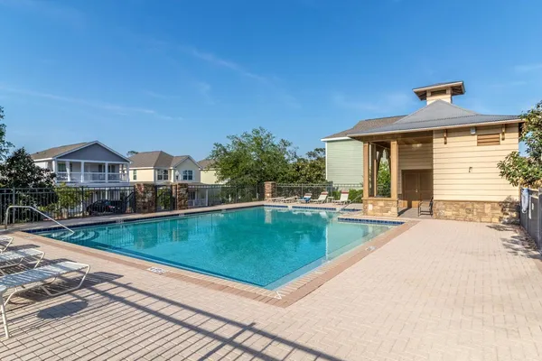 a view of a house with pool and chairs