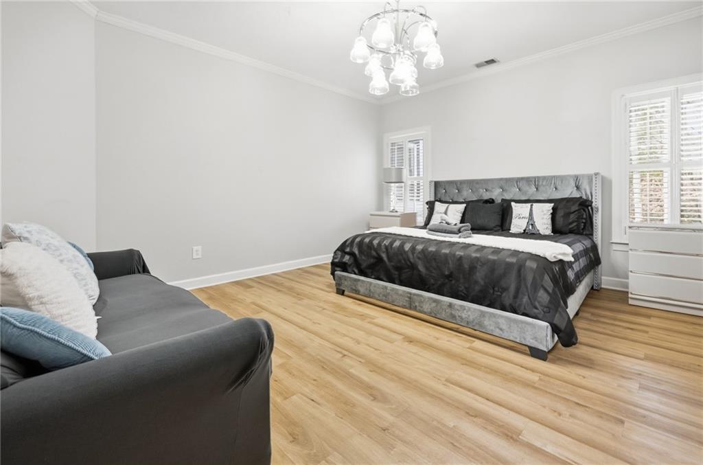 4670 Hamden Forest Drive Southwest Atlanta, GA 30331 - Photo 31 of 68 a bedroom with a large bed and a chandelier