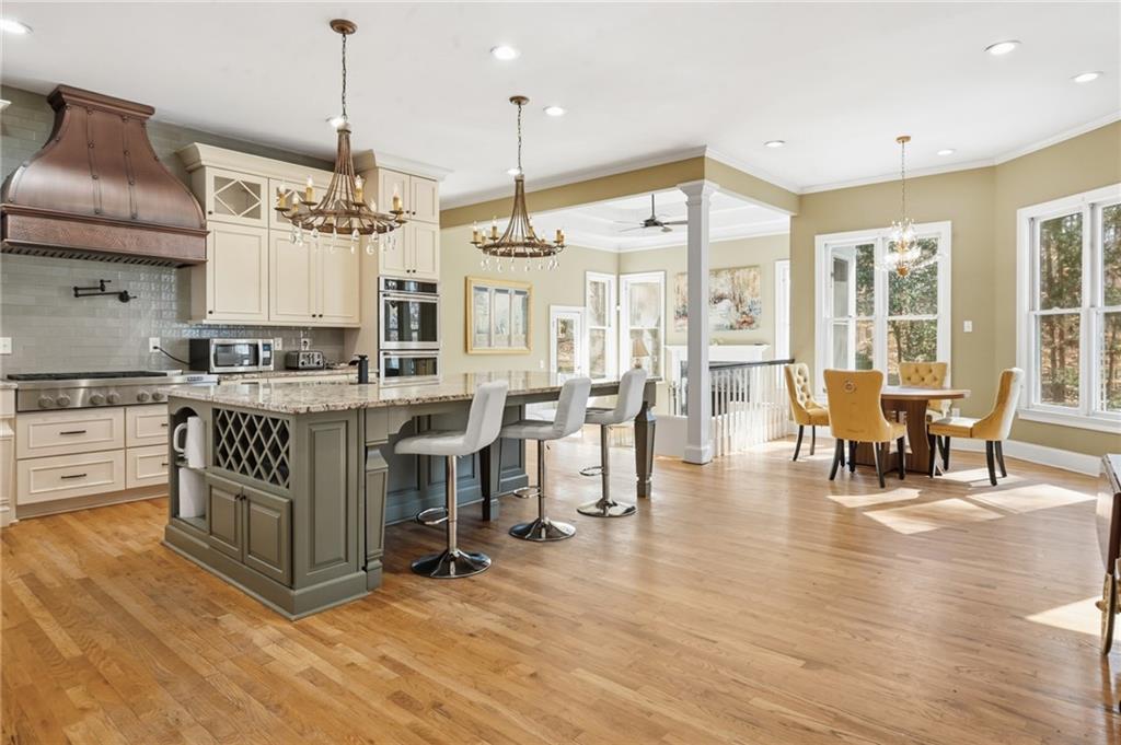 4670 Hamden Forest Drive Southwest Atlanta, GA 30331 - Photo 53 of 68 a kitchen with stainless steel appliances granite countertop a stove oven a dining table and chairs with wooden floor