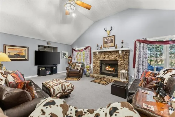 a living room with furniture a fireplace and a chandelier