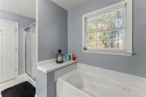 a bedroom with a bed and a flat tv screen on dresser