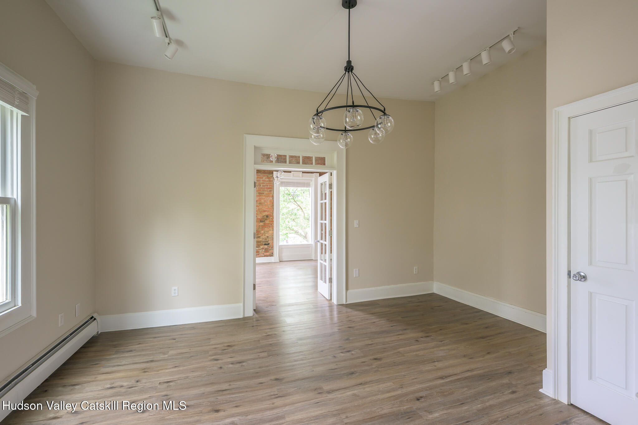 237 Warren Street Hudson, NY 12534 - Photo 19 of 39 a view of a room with wooden floor chandeliers and a window