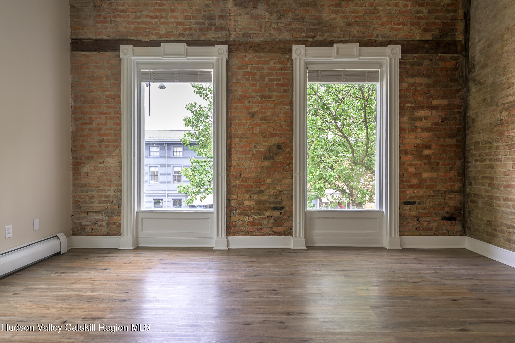 237 Warren Street Hudson, NY 12534 - Photo 23 of 39 an empty room with wooden floor and windows