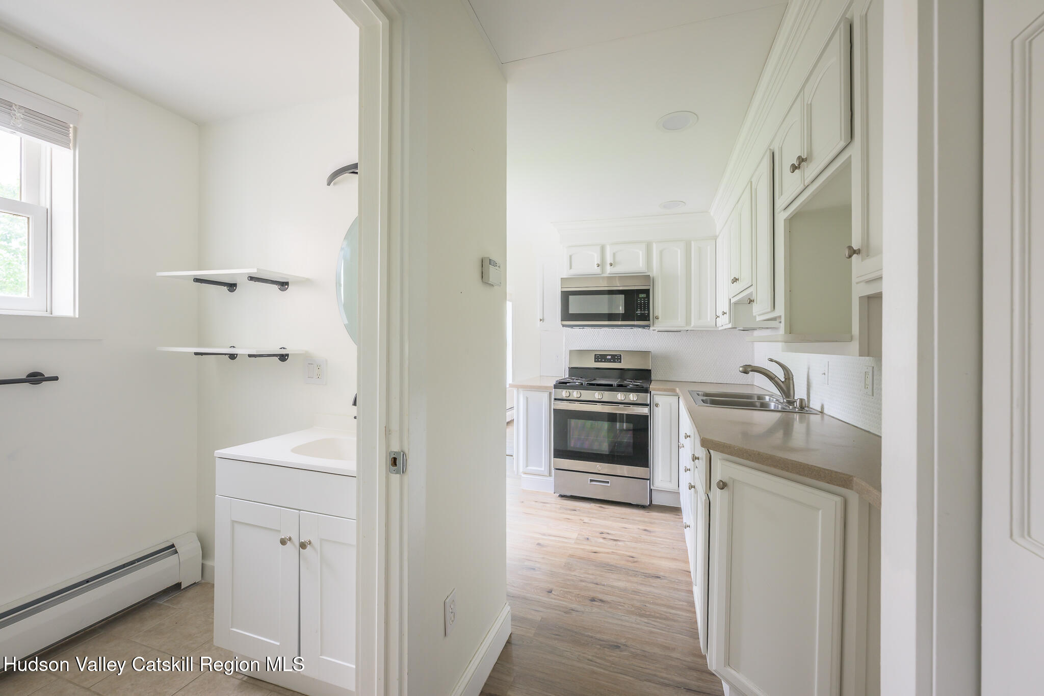 237 Warren Street Hudson, NY 12534 - Photo 26 of 39 a kitchen with white cabinets and stainless steel appliances