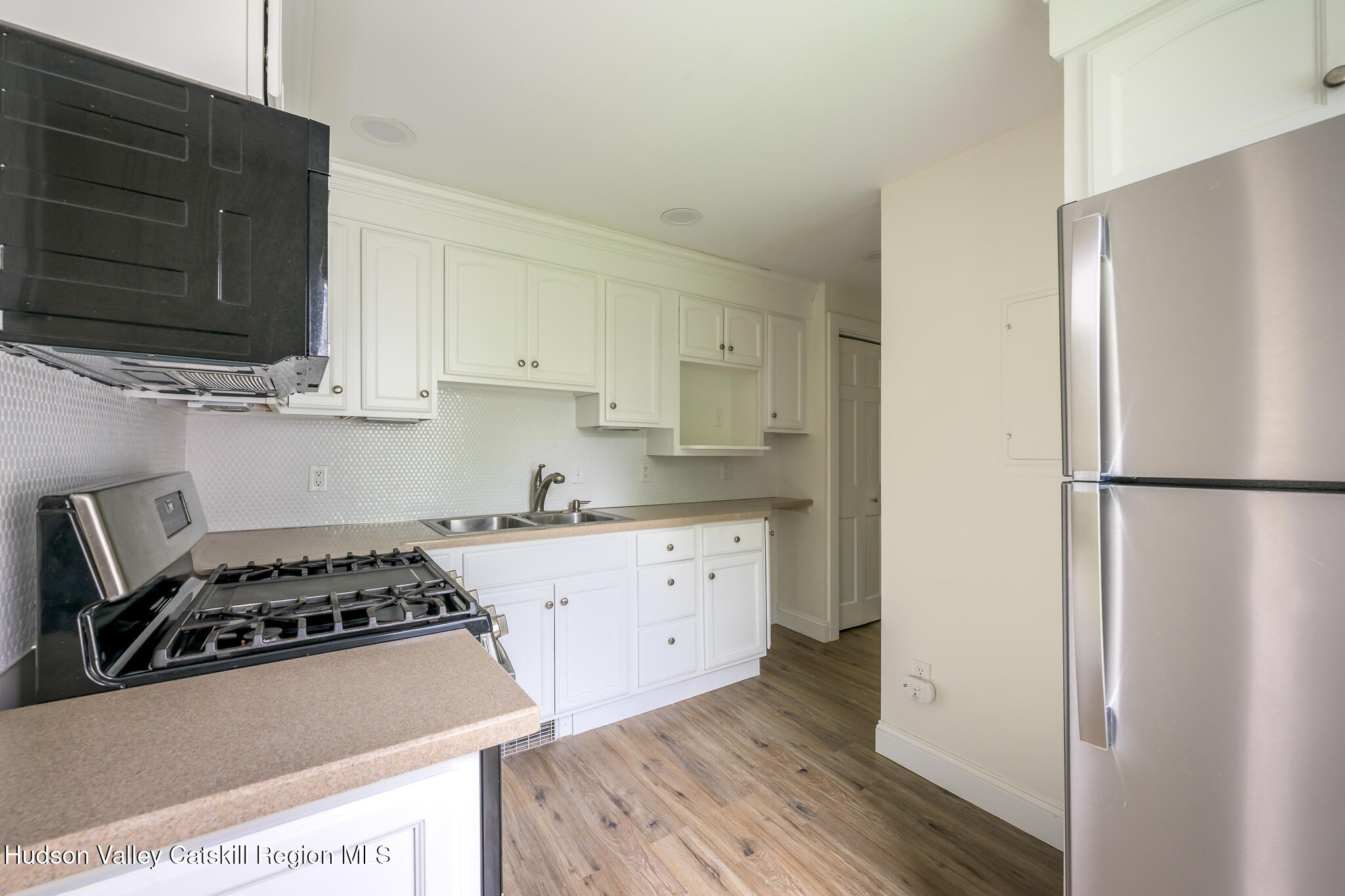 237 Warren Street Hudson, NY 12534 - Photo 29 of 39 a kitchen with a refrigerator a stove a microwave and cabinets
