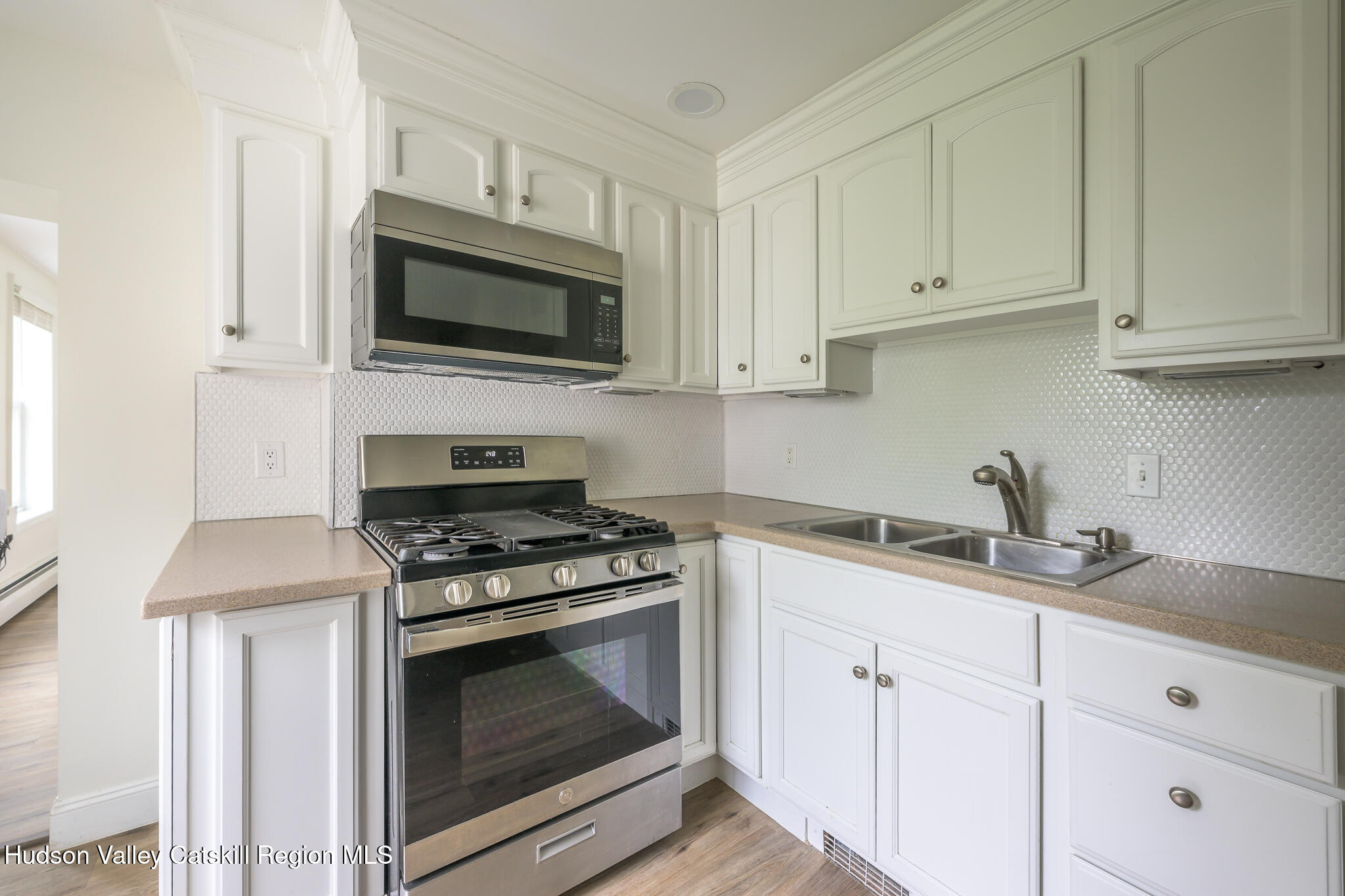 237 Warren Street Hudson, NY 12534 - Photo 30 of 39 a kitchen with granite countertop white cabinets and appliances