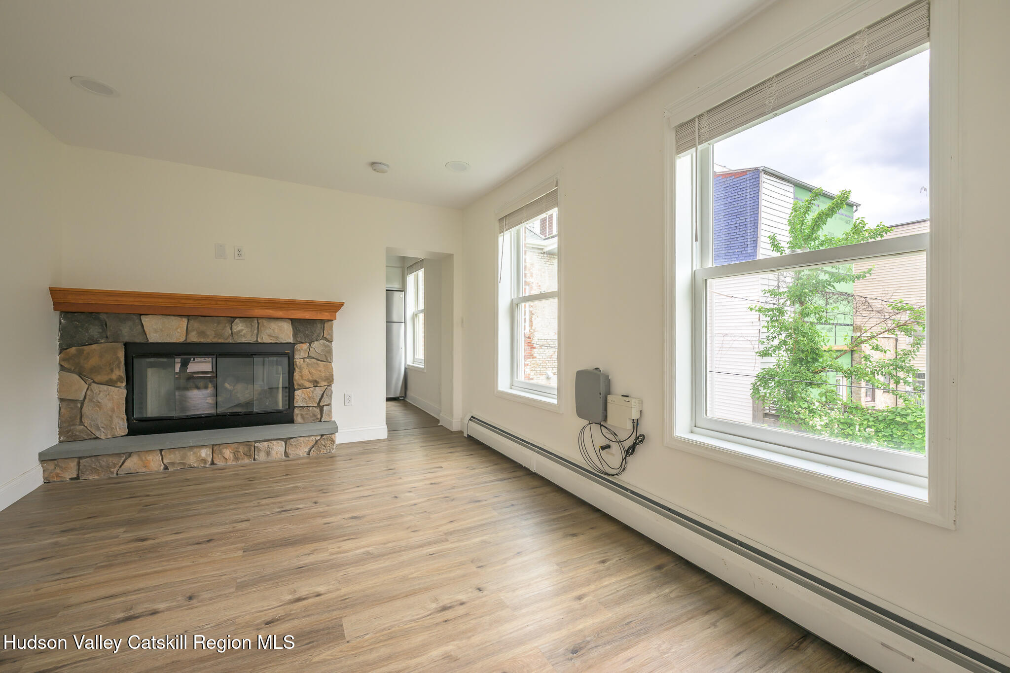 237 Warren Street Hudson, NY 12534 - Photo 31 of 39 a living room with hardwood floor and a fireplace