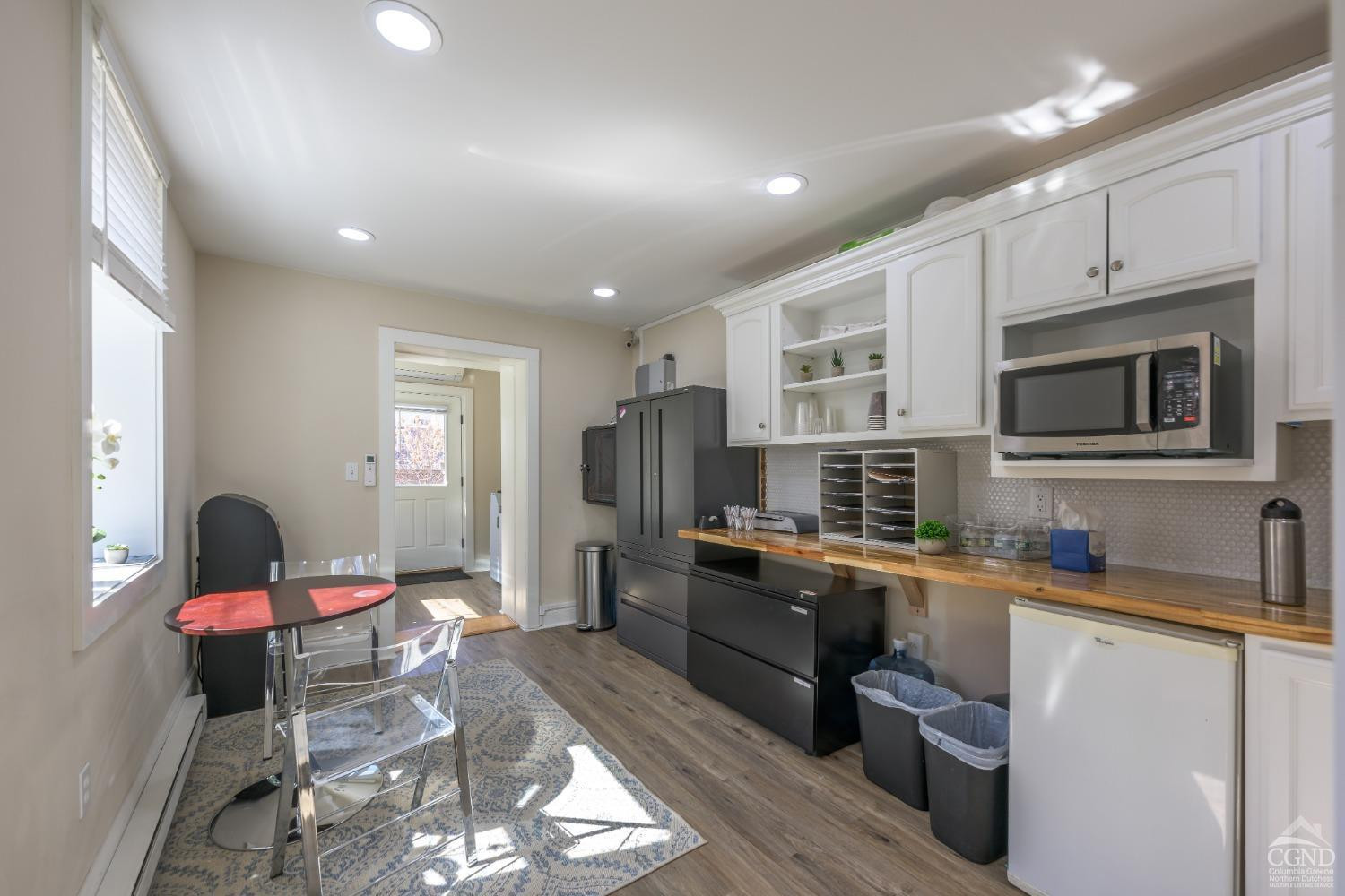 237 Warren Street Hudson, NY 12534 - Photo 8 of 39 a kitchen with refrigerator a stove top oven a sink dishwasher and white cabinets with wooden floor