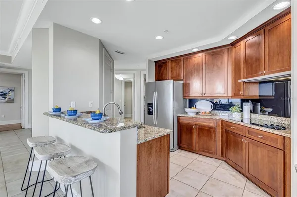 a kitchen with stainless steel appliances granite countertop a stove refrigerator sink and cabinets