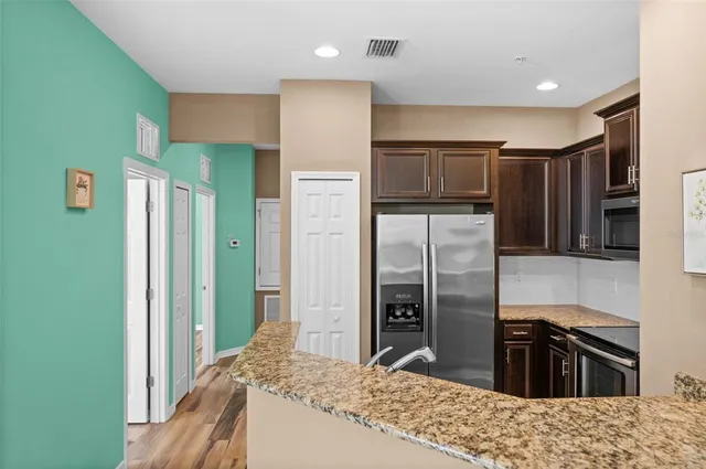 a kitchen with granite countertop a refrigerator and a sink