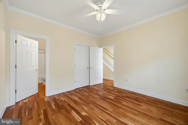 an empty room with windows and ceiling fan