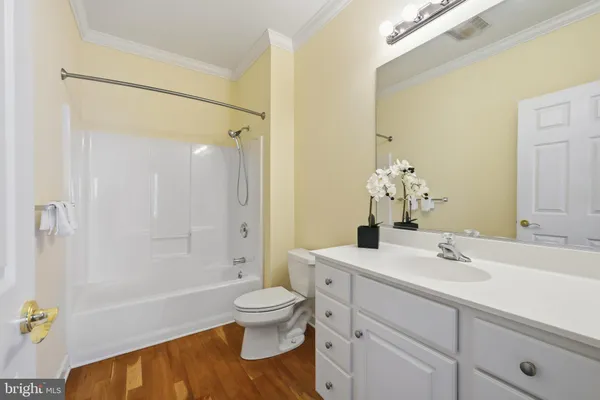 a bathroom with a granite countertop sink a toilet and bathtub
