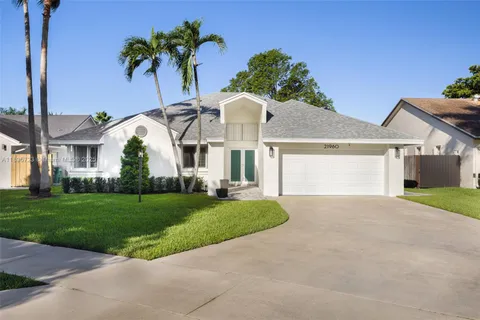 a view of a house with a yard and potted plants