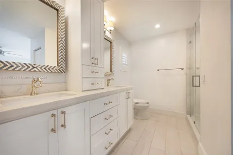 a spacious bathroom with a granite countertop sink a toilet a and a mirror
