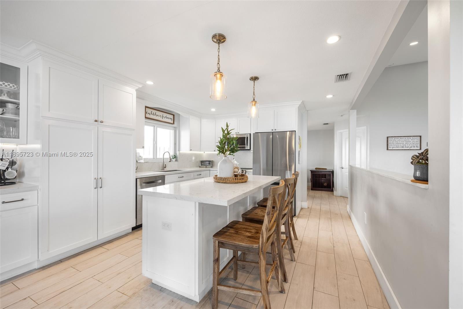 21960 Southwest 98th Avenue Cutler Bay, FL 33190 - Photo 8 of 25 a kitchen with stainless steel appliances kitchen island granite countertop a refrigerator a sink a stove and white cabinets with wooden floor