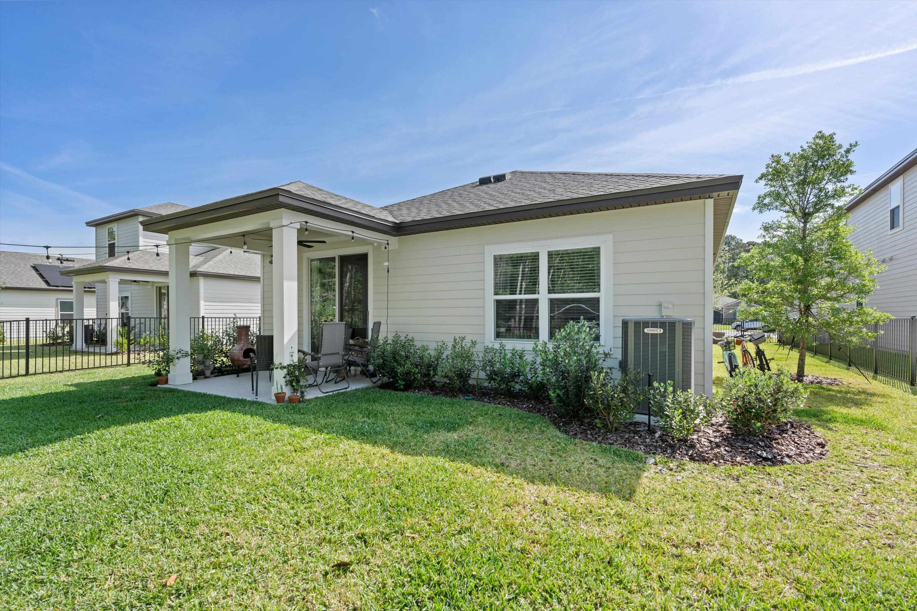 793 Morgans Treasure Road St. Augustine, FL 32084 - Photo 22 of 24 a front view of a house with a yard and potted plants